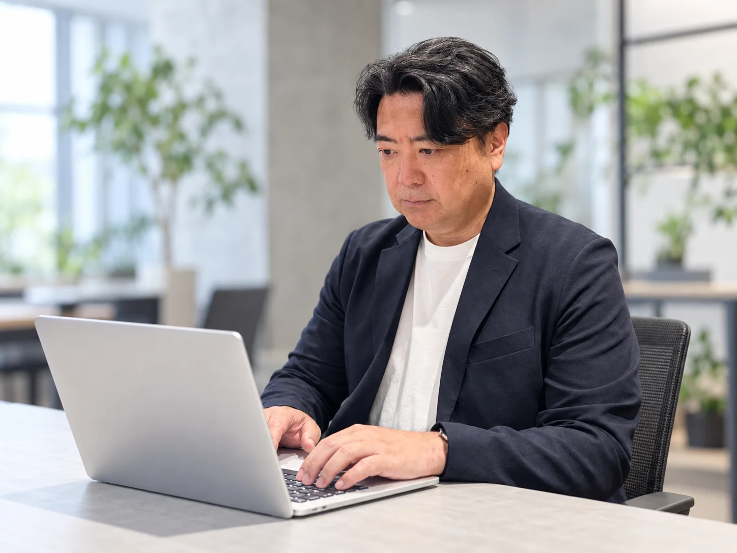 代表の遠藤友治がPCで作業している様子